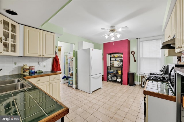 133 S Prospect Ave, Baltimore, MD 21228 - kitchen featuring freestanding refrigerator, a sink, tile countertops, and under cabinet range hood