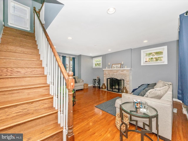 3812 Callaway Ave, Baltimore, MD 21215 - living room featuring wood finished floors, stairs, a tile fireplace, recessed lighting, and baseboards