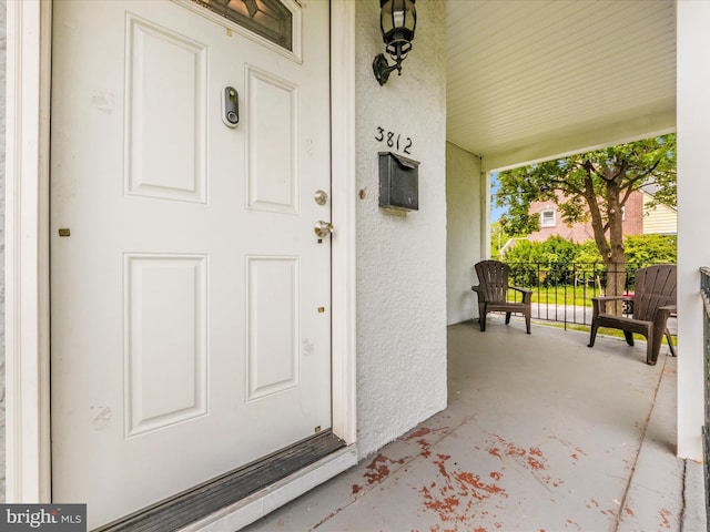 3812 Callaway Ave, Baltimore, MD 21215 - doorway to property featuring covered porch and stucco siding