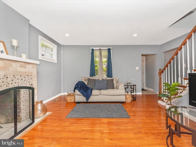3812 Callaway Ave, Baltimore, MD 21215 - living room with wood finished floors, stairs, baseboards, recessed lighting, and a tiled fireplace