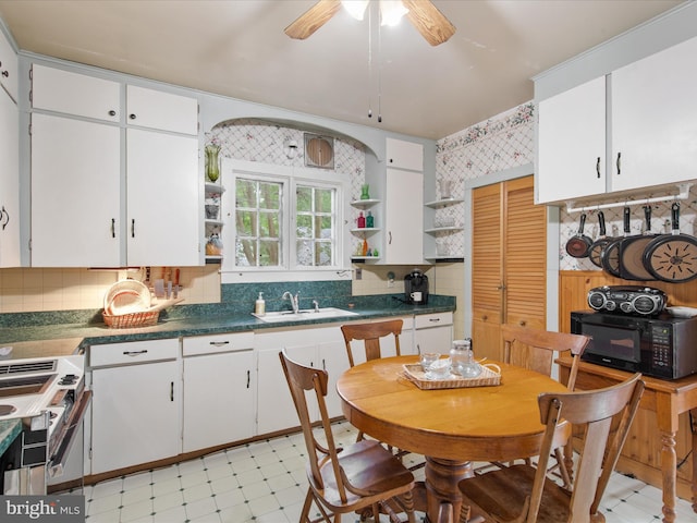 140 Delaware Ave, Laurel, DE 19956 - kitchen with open shelves, black microwave, light flooring, stove, and white cabinets