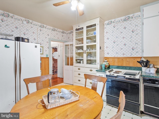 140 Delaware Ave, Laurel, DE 19956 - kitchen with wallpapered walls, freestanding refrigerator, electric range, a wainscoted wall, and a ceiling fan