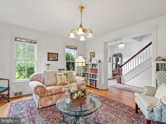 140 Delaware Ave, Laurel, DE 19956 - living area with plenty of natural light, arched walkways, wood finished floors, a chandelier, and crown molding