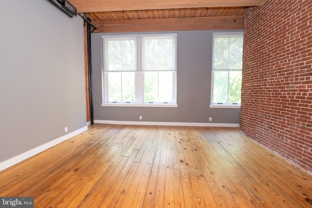 309 Arch St Unit 301, Philadelphia, PA 19106 - unfurnished room featuring brick wall, light wood finished floors, baseboards, wood ceiling, and a barn door