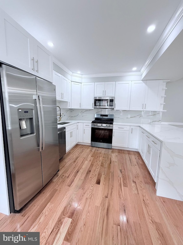 56 E Tulpehocken St, Philadelphia, PA 19144 - kitchen with appliances with stainless steel finishes, white cabinetry, light stone countertops, a sink, and backsplash
