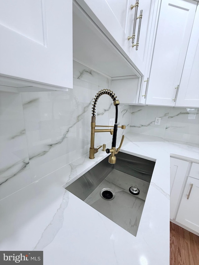 56 E Tulpehocken St, Philadelphia, PA 19144 - kitchen view of a sink, white cabinetry, light stone countertops, and tasteful backsplash