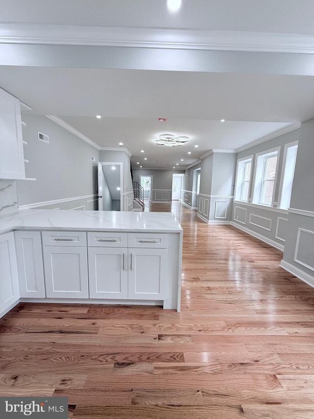 56 E Tulpehocken St, Philadelphia, PA 19144 - kitchen featuring a decorative wall, crown molding, light wood-style flooring, white cabinetry, and a peninsula