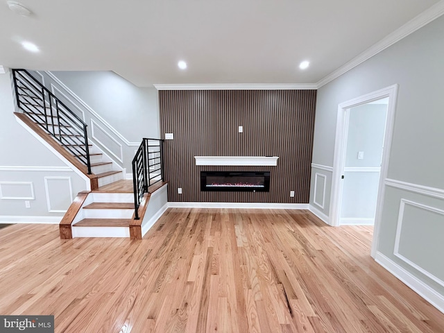 56 E Tulpehocken St, Philadelphia, PA 19144 - unfurnished living room with a decorative wall, stairway, wood finished floors, ornamental molding, and a glass covered fireplace