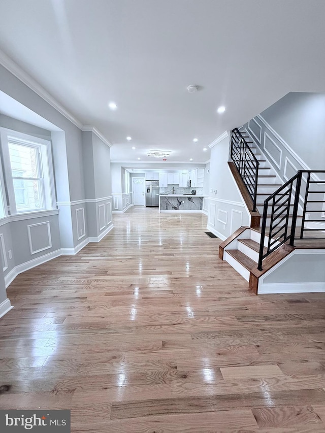 56 E Tulpehocken St, Philadelphia, PA 19144 - unfurnished living room with ornamental molding, a decorative wall, stairway, recessed lighting, and light wood-style floors