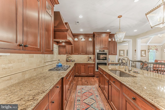 217 Valley Ridge Rd, Haverford, PA 19041 - kitchen with stainless steel appliances, custom exhaust hood, dark wood-style floors, hanging light fixtures, and glass insert cabinets