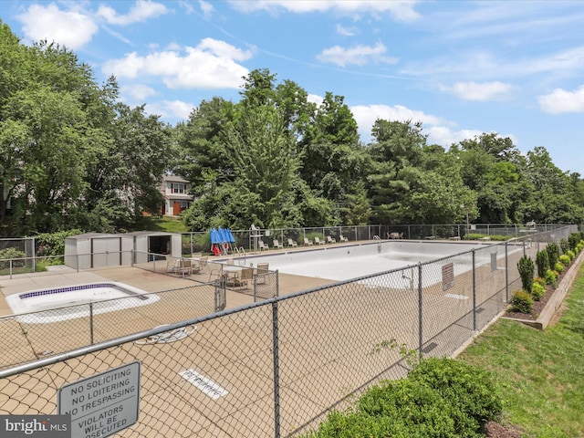4514 Running Deer Way Unit 390A, Bowie, MD 20720 - view of swimming pool featuring view of wooded area and a storage shed