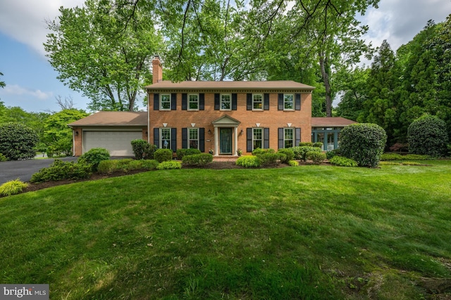 9017 Rouen Ln, Potomac, MD 20854 - colonial inspired home with an attached garage, brick siding, a chimney, driveway, and a front lawn