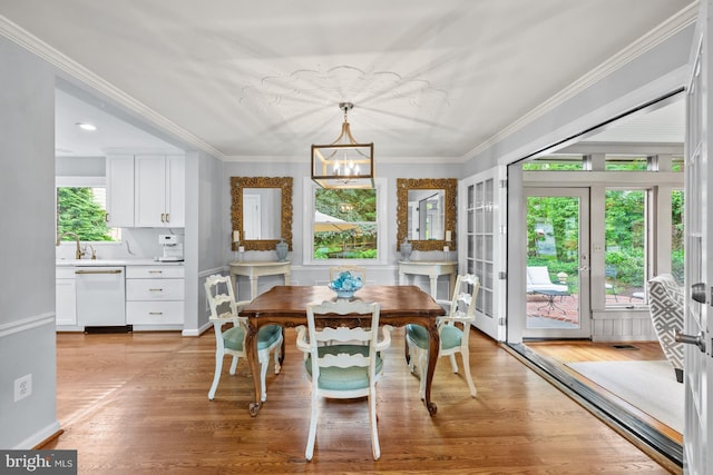 9017 Rouen Ln, Potomac, MD 20854 - dining space featuring a chandelier, light wood-type flooring, and crown molding