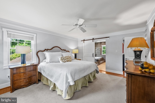 9017 Rouen Ln, Potomac, MD 20854 - bedroom with a barn door, multiple windows, baseboards, ensuite bathroom, and crown molding