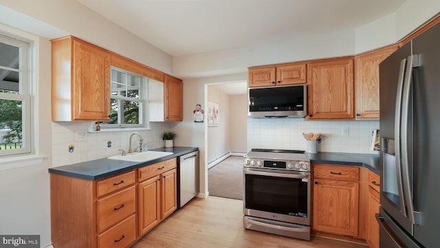 17 Rosemore Dr, Chalfont, PA 18914 - kitchen featuring stainless steel appliances, dark countertops, light wood-style flooring, and tasteful backsplash