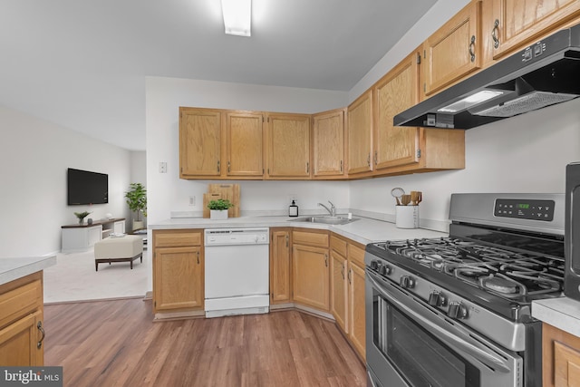 1712 W 14th St, Wilmington, DE 19806 - kitchen with dishwasher, stainless steel gas range, under cabinet range hood, a sink, and light wood finished floors
