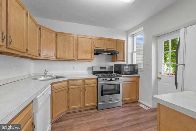 1712 W 14th St, Wilmington, DE 19806 - kitchen with white appliances, a sink, under cabinet range hood, light wood finished floors, and light countertops