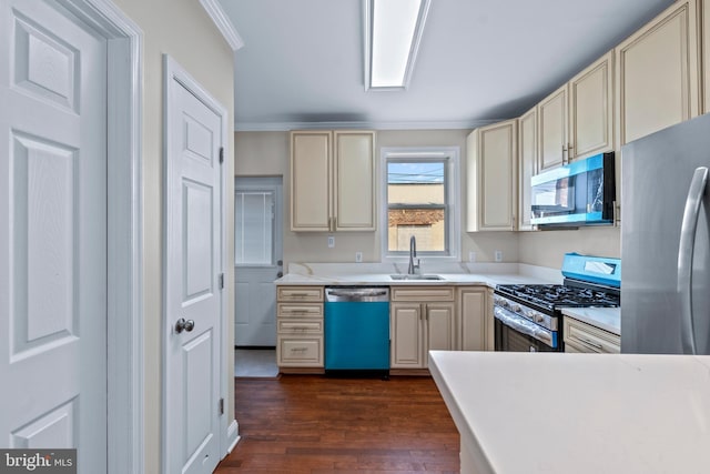 1521 Bush St, Baltimore, MD 21230 - kitchen with stainless steel appliances, cream cabinetry, ornamental molding, dark wood-style floors, and light countertops