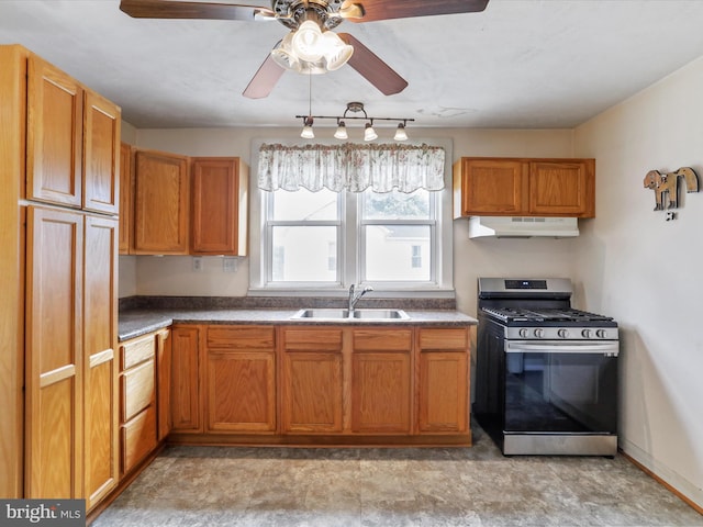 12225 Upper Georges Creek Rd SW, Frostburg, MD 21532 - kitchen with stainless steel gas range, under cabinet range hood, ceiling fan, dark countertops, and brown cabinets