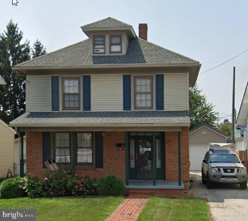 23 Ridge Ave, Hanover, PA 17331 - american foursquare style home featuring covered porch, a chimney, a detached garage, and a front lawn