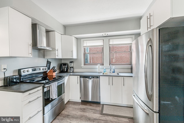 23 Ridge Ave, Hanover, PA 17331 - kitchen with appliances with stainless steel finishes, wall chimney range hood, a sink, light wood finished floors, and dark countertops