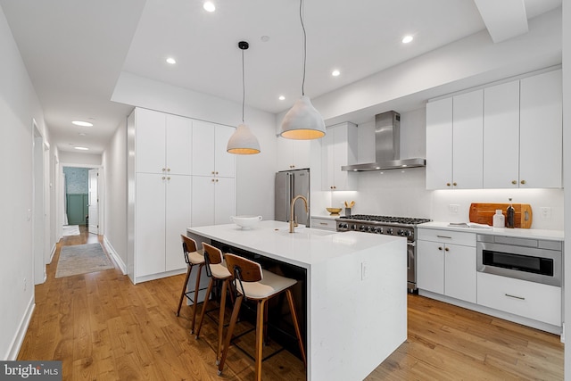 262 S 16th St Unit 7, Philadelphia, PA 19102 - kitchen with wall chimney exhaust hood, stainless steel appliances, light wood-style flooring, a sink, and recessed lighting