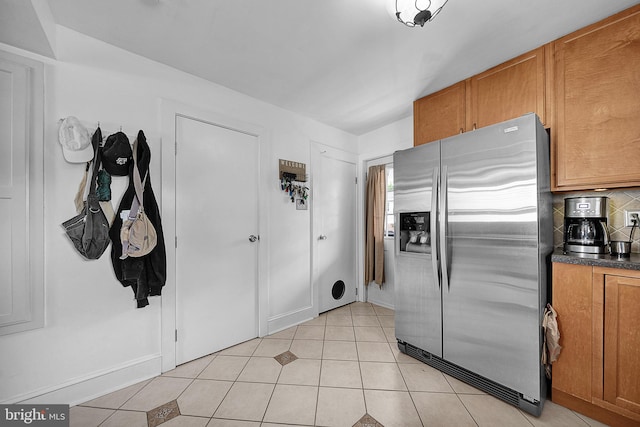320 Pearl Ave, Horsham, PA 19044 - kitchen with stainless steel fridge, dark countertops, backsplash, brown cabinetry, and light tile patterned flooring