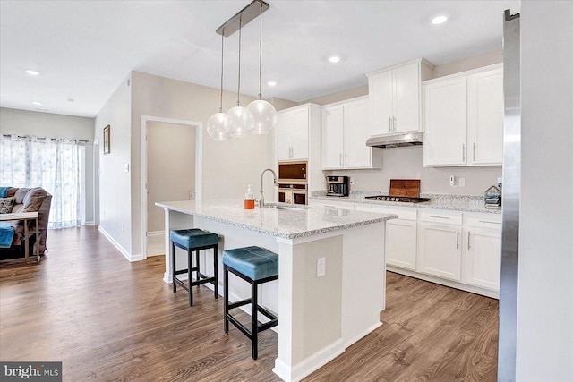27 Quiet Creek Dr, Gettysburg, PA 17325 - kitchen with under cabinet range hood, gas stovetop, wood finished floors, an island with sink, and recessed lighting