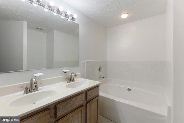 Goose Landing Cir, Columbia, MD 21044 - bathroom featuring a garden tub, double vanity, a textured ceiling, and tile patterned floors
