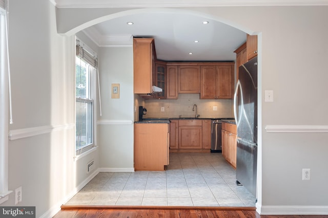 2413 Childs Ln, Alexandria, VA 22308 - kitchen with stainless steel appliances, arched walkways, decorative backsplash, glass insert cabinets, and light tile patterned floors