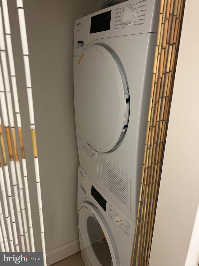 2429 Locust St Unit 217, Philadelphia, PA 19103 - laundry room featuring stacked washing machine and dryer and tile patterned floors