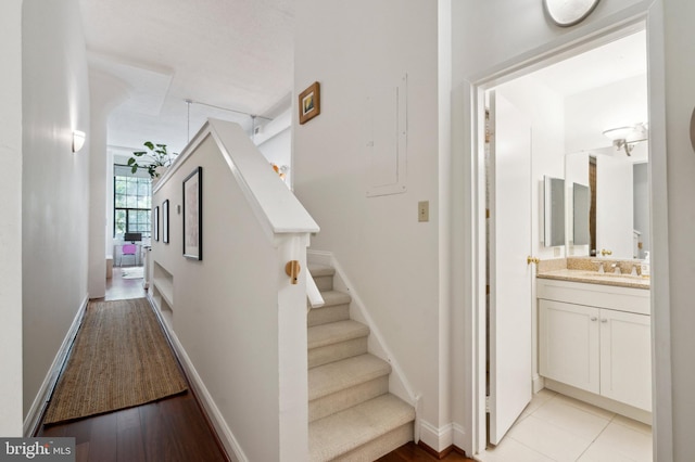 2429 Locust St Unit 217, Philadelphia, PA 19103 - hallway featuring stairs, a sink, baseboards, and light wood-style flooring