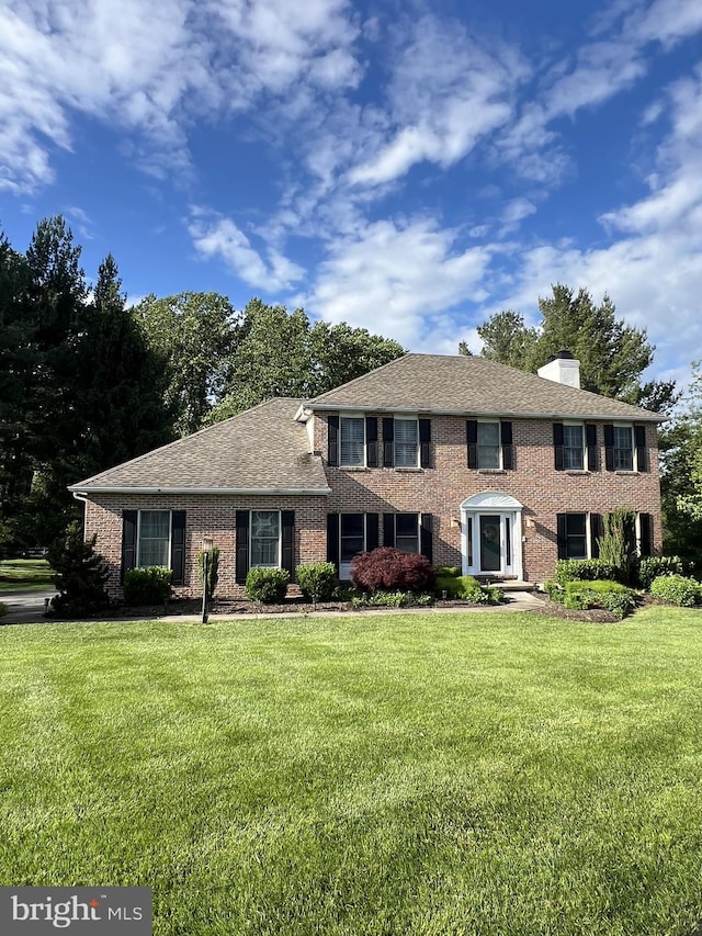 4 Pine Tree Ct, Hockessin, DE 19707 - colonial-style house with a front yard, brick siding, and a chimney