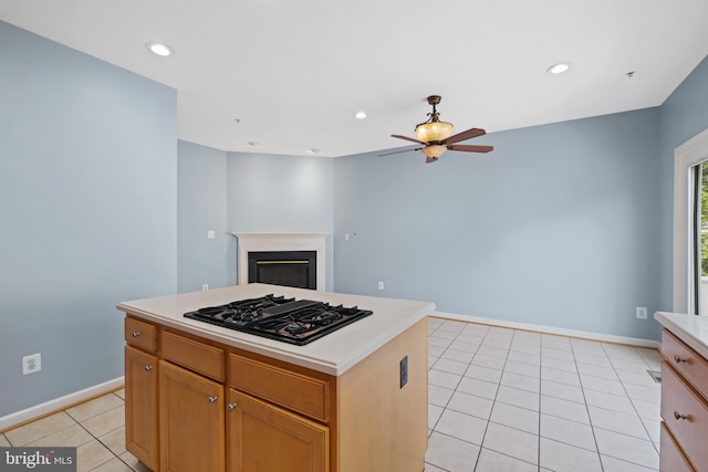 10728 Horde St, Silver Spring, MD 20902 - kitchen with black gas cooktop, a ceiling fan, light tile patterned flooring, light countertops, and a fireplace