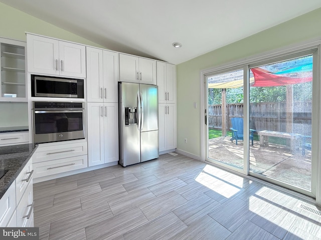 231 E Juniper Ave, Sterling, VA 20164 - kitchen featuring stainless steel appliances, vaulted ceiling, white cabinetry, dark stone countertops, and recessed lighting