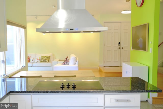 231 E Juniper Ave, Sterling, VA 20164 - kitchen featuring island range hood, white cabinetry, dark stone countertops, and healthy amount of natural light