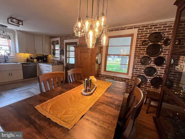9108 Deborah Ave, Baltimore, MD 21236 - dining room featuring plenty of natural light, brick wall, wood finished floors, and a chandelier