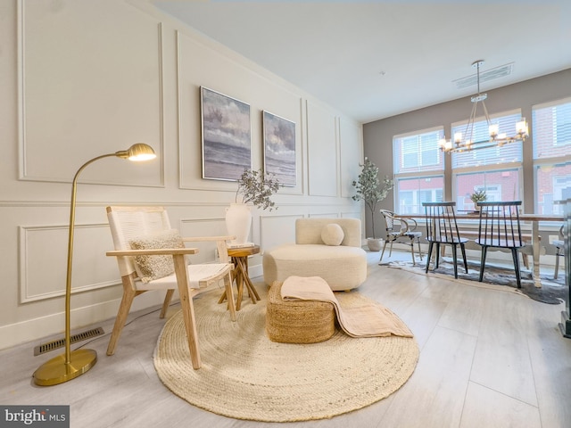 1949 Roland Clarke Pl, Reston, VA 20191 - living area featuring a decorative wall, a chandelier, healthy amount of natural light, and wood finished floors