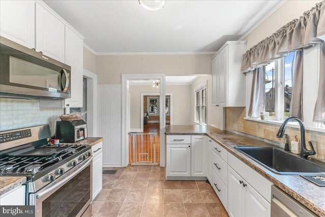 200 Winston Ave, Wilmington, DE 19804 - kitchen featuring appliances with stainless steel finishes, white cabinetry, tasteful backsplash, ornamental molding, and wainscoting