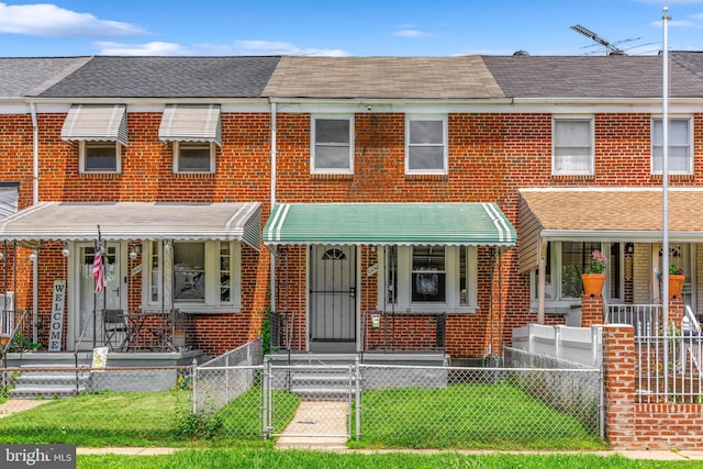 8450 Kavanagh Rd, Dundalk, MD 21222 - view of property featuring covered porch, brick siding, a gate, and a fenced front yard
