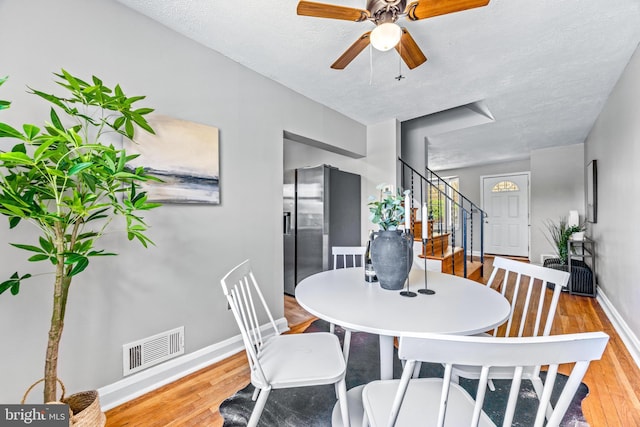 8450 Kavanagh Rd, Dundalk, MD 21222 - dining area featuring stairs, wood finished floors, ceiling fan, and a textured ceiling