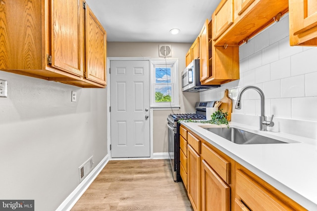 8450 Kavanagh Rd, Dundalk, MD 21222 - kitchen with stainless steel appliances, decorative backsplash, light countertops, light wood finished floors, and brown cabinetry