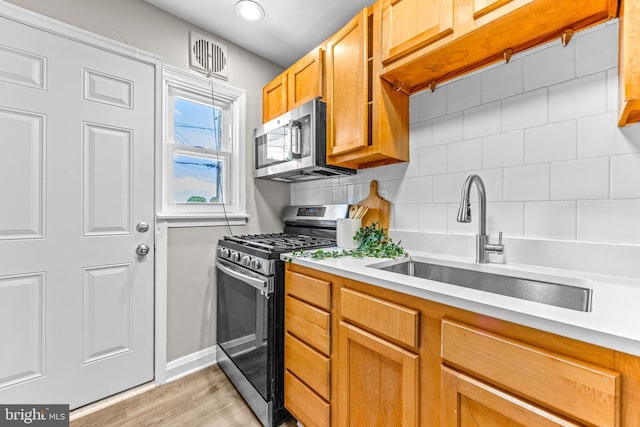 8450 Kavanagh Rd, Dundalk, MD 21222 - kitchen with appliances with stainless steel finishes, light wood-style floors, decorative backsplash, light countertops, and recessed lighting