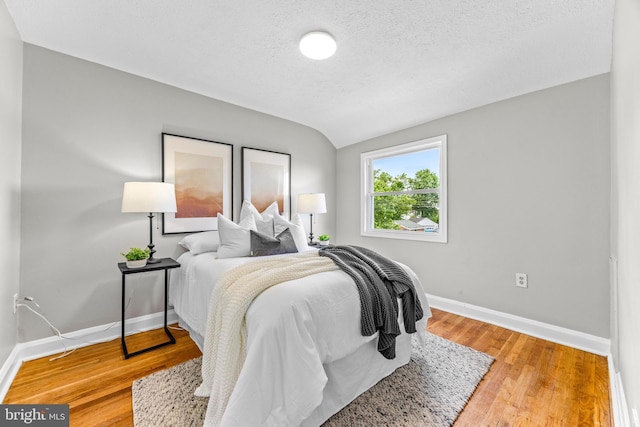 8450 Kavanagh Rd, Dundalk, MD 21222 - bedroom featuring wood finished floors, a textured ceiling, and lofted ceiling
