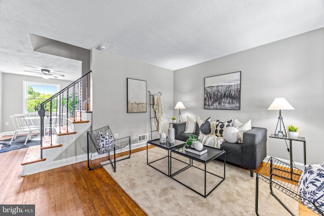8450 Kavanagh Rd, Dundalk, MD 21222 - living room featuring stairway, a textured ceiling, hardwood / wood-style floors, and ceiling fan