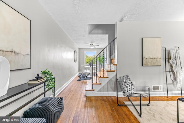 8450 Kavanagh Rd, Dundalk, MD 21222 - corridor featuring stairway, wood-type flooring, and a textured ceiling