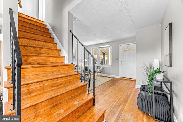 8450 Kavanagh Rd, Dundalk, MD 21222 - foyer entrance with stairs, a textured ceiling, and light wood-style floors