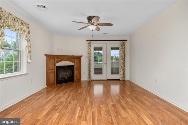 13336 Marquise Dr, Hagerstown, MD 21742 - unfurnished living room with light wood finished floors, french doors, baseboards, and a glass covered fireplace