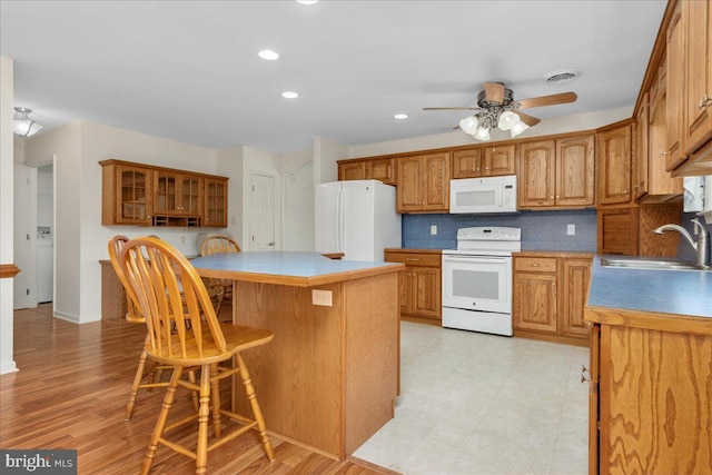 13336 Marquise Dr, Hagerstown, MD 21742 - kitchen featuring white appliances, a sink, a kitchen island, brown cabinets, and recessed lighting