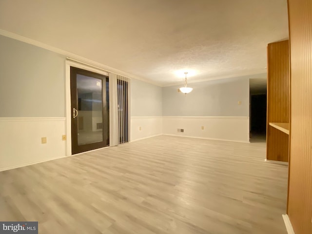 751 Heather Ridge Dr Unit 18E, Frederick, MD 21702 - empty room featuring ornamental molding, wood finished floors, a wainscoted wall, and a textured ceiling